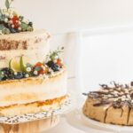 brown cake with green and red fruit on white ceramic plate