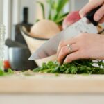 person cutting vegetables with knife