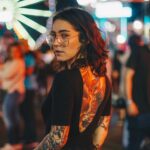 portrait photography of woman standing near Ferris Wheel