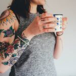 woman holding white ceramic mug